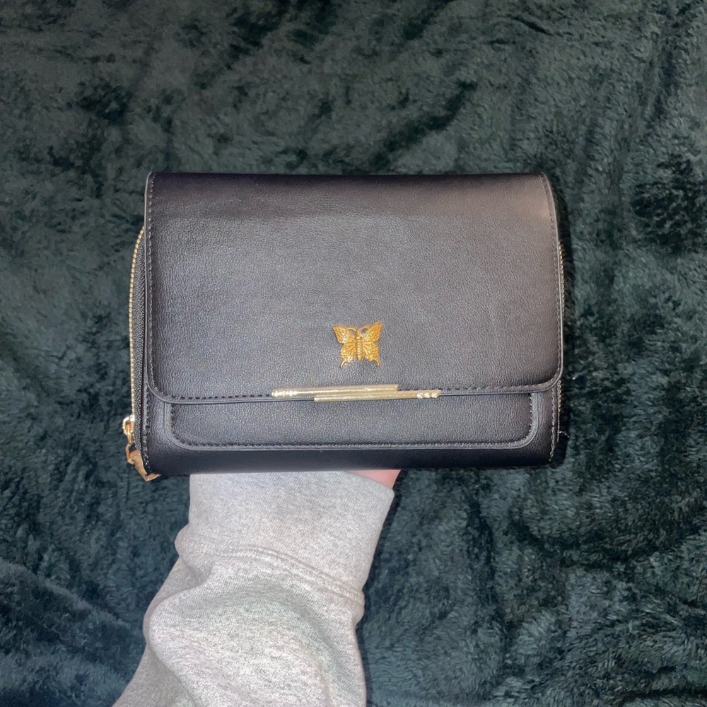 Small black purse with gold butterfly detailing.